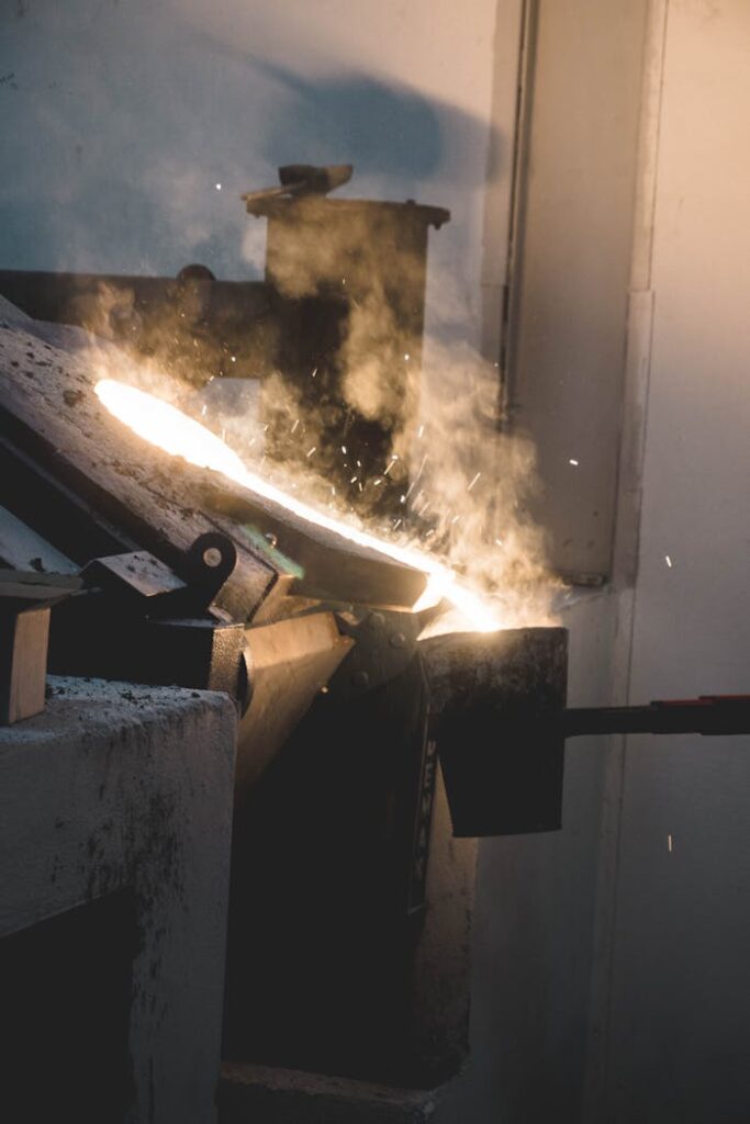 Molten metal being poured in an industrial setting, showcasing intense heat and light.